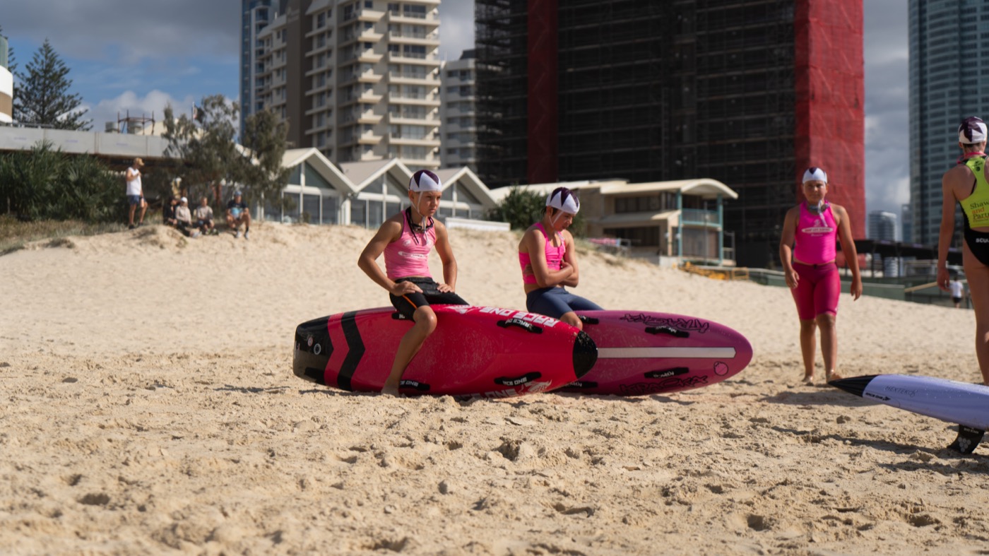 Nippers waiting on their boards on the sand between beach events